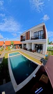 a house with a swimming pool in front of it at Sekar Uluwatu in Uluwatu