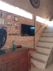 a staircase with a flat screen tv on a brick wall at Espaço Além da Lenda in Alexânia