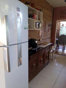 a kitchen with a white refrigerator and a table at Espaço Além da Lenda in Alexânia +6 photos