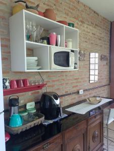 a kitchen with a counter top with a microwave at Espaço Além da Lenda in Alexânia