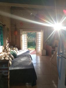 a bedroom with a bed with the sun shining on it at Espaço Além da Lenda in Alexânia