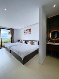 a bedroom with a large bed and a mirror at The SeaNest Home - Làng Chài Mỹ Tân Ninh Thuận in Vinh Hai