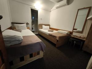 a hotel room with two beds and a mirror at Pensiunea Irina in Brad