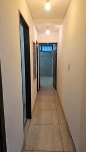 a hallway of a house with white walls and a tile floor at Nova in Mendoza