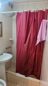 a bathroom with a red shower curtain and a sink at Nova in Mendoza
