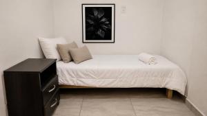 a bedroom with a bed with a black dresser at Nova in Mendoza