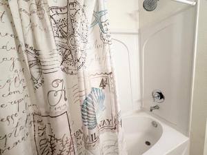 a bathroom with a shower curtain and a bath tub at Disney Kissimmee Condo in Kissimmee +9 photos