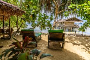 two chairs and a hut on a beach at Alter Native Stay in Tapokreng
