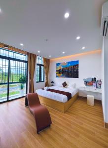 a large bedroom with a bed and a chair at Hotel Trung Đông 2 in Ấp Bình Thương