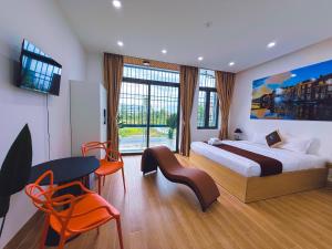 a hotel room with a bed and a table and chairs at Hotel Trung Đông 2 in Ấp Bình Thương
