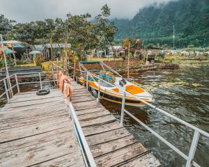 a boat is docked next to a wooden dock at Catur Glamping Bedugul in Bedugul