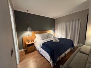a bedroom with a bed with a blue blanket and a chair at Apart Hotel Itaim Bibi in São Paulo +12 photos