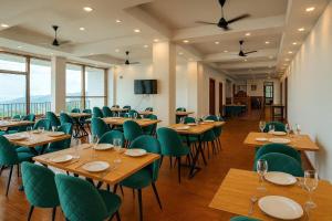 a restaurant with wooden tables and green chairs at Serene Forest Resort in Nainital