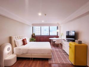 a bedroom with a bed and a table and a television at Glocaloca gwanghwamun in Seoul