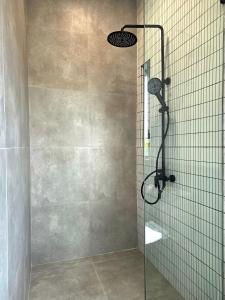 a bathroom with a shower with a shower head at Sekar Uluwatu in Uluwatu +41 photos