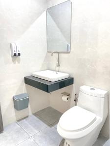 a bathroom with a toilet and a sink and a mirror at Aten hotel in Sathani Khao Pip +22 photos