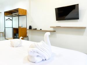 two white swans on a bed in a room at Aten hotel in Sathani Khao Pip