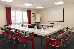 a conference room with a large table and chairs at Armony Hotel in Bourg-Achard