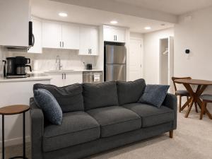 a living room with a couch and a kitchen at Modern 2BR Private Suite in SW Calgary in Calgary