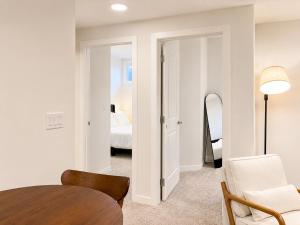 a living room with a table and a bedroom at Modern 2BR Private Suite in SW Calgary in Calgary