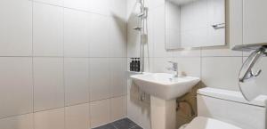 a white bathroom with a sink and a toilet at Hotel Barley Field Seoknam in Incheon