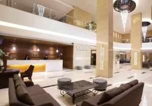 a lobby with couches and a table in a building at Grand Mercure Solo Baru in Solo