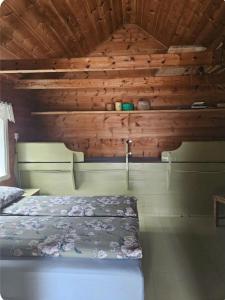 a bedroom with a bed and a wooden ceiling at Hardanger Kulturgalleri in Herand