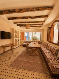 a living room with a couch and a table at Kymata Surf Morocco in Agadir