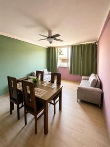 a dining room with a table and chairs and a couch at Puul Suites in Mérida +18 photos