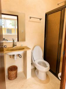 a bathroom with a toilet and a sink at Puul Suites in Mérida