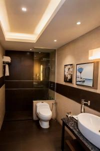 a bathroom with a toilet and a sink at D'more Dhaka Hotel & Resort in Dhaka