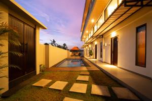a courtyard of a house with a swimming pool at Lunaire Guest House in Tabanan