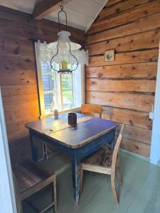 a wooden dining room with a wooden table and chairs at Hardanger Kulturgalleri in Herand