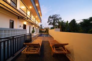 a row of chairs on a balcony of a building at Lunaire Guest House in Tabanan