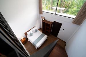 a small bedroom with a bed and a window at Lunaire Guest House in Tabanan