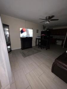 a living room with a ceiling fan and a television at Clearwater Beach Getaway Clearwater in Clearwater