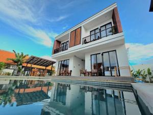 a house with a swimming pool in front of it at Sekar Uluwatu in Uluwatu
