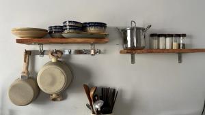 a kitchen with wooden shelves with pans and utensils at Nồm House in Nha Trang