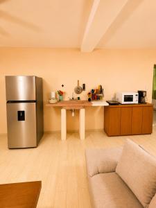 a kitchen with a stainless steel refrigerator and a counter at Puul Suites in Mérida