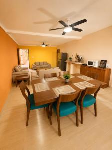 a dining room and living room with a table and chairs at Puul Suites in Mérida