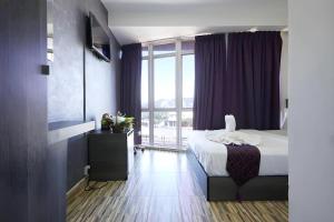 a bedroom with a bed and a large window at Fast Hotel Idaman Near To IIUM KL in Kuala Lumpur