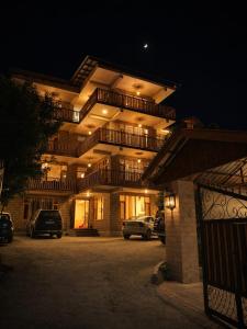 a building with cars parked in a parking lot at night at Crest Manali River View in Manāli +25 photos