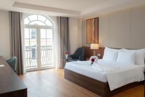 a hotel room with a large bed and a window at Devesun Boutique Hotel Phú Quốc in Phú Quốc