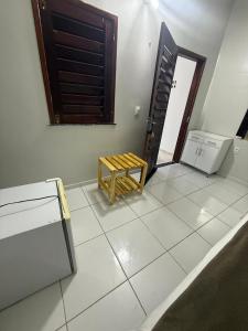 a room with a bench sitting on a tiled floor at Suíte Brisa Mar Villa brisa icaraizinho in Amontada