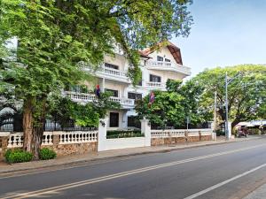 a white building on the side of a street at Chateau d'Angkor La Residence in Siem Reap