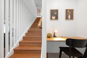 a staircase leading up to a home office with a desk at Stylish Clontarf Townhouse & Parking in Clontarf +23 photos