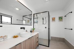 a white bathroom with a sink and a shower at Stylish Clontarf Townhouse & Parking in Clontarf