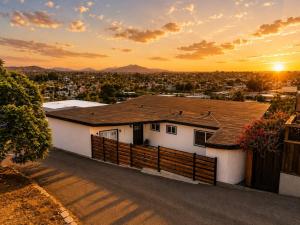 a white house with a fence in front of a city at 2Homes Villa Renovated Views in La Mesa
