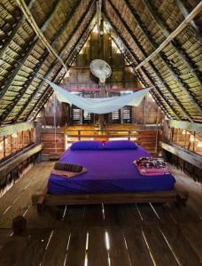 a bedroom with a bed in a wooden house at Eco Lotus Kampot in Kampot