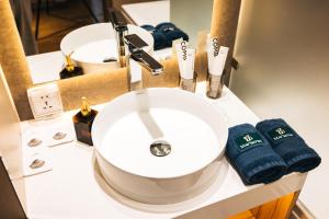 a bathroom counter with a sink and two towels at May Seven Hotel and Suites in Ulaanbaatar